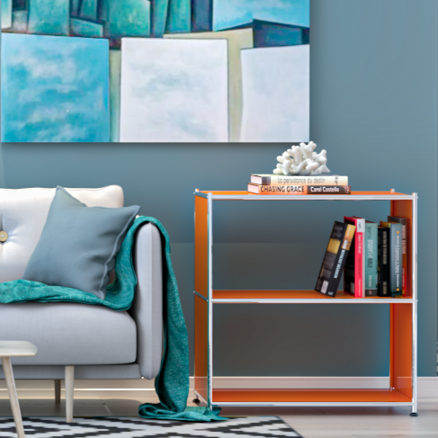 Orange metal bookcase styled with books beside sofa in modern living room